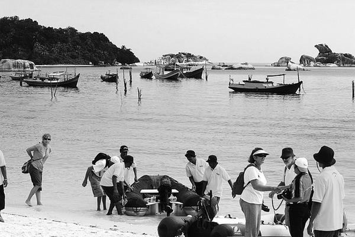 Sejumlah peserta Sail Indonesia 2010 turun dari sekoci di Pantai Tanjung Kalayang, Pulau Belitong. Sekoci itu membawa mereka dari perahu layar tiang tinggi yang melepas jangkar agak di tengah laut.