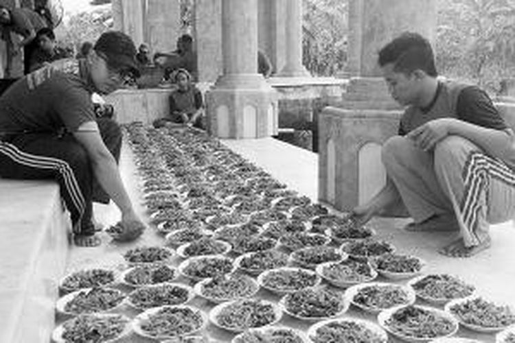 Remaja pria di Desa Gumeno, Kecamatan Manyar, Kabupaten Gresik, Jawa Timur, Minggu (20/7/2014), dilibatkan dalam menata kolak ayam untuk warga sekitar. Tradisi sanggringan, yakni berbuka bersama dengan menyantap kolak ayam, di Masjid Jami’ Sunan Dalem Desa Gumeno sudah berlangsung 489 tahun atau sejak 22 Ramadhan 946 Hijriah. Kolak ayam selalu dimasak laki-laki dan untuk regenerasi setiap tahun dipilih satu generasi terbaru untuk terlibat dalam memasak kolak ayam.