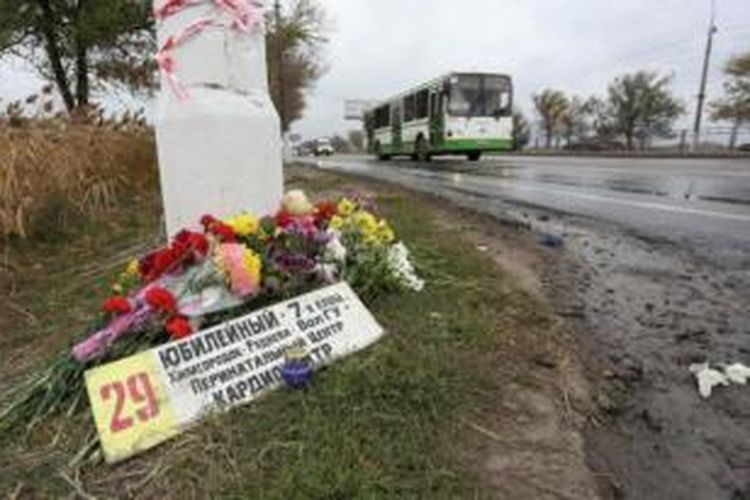 Karanan bunga diletakkan di lokasi bom bunuh diri di sebuah bus kota di Volgograd, Rusia. Polisi Rusia kini memburu suami Naida Asiyalova, pelaku bom bunuh diri, yang diyakini merupakan otak insiden itu.