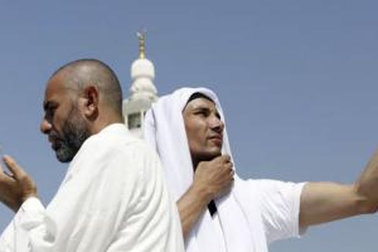 Seorang jemaah haji berdoa sementara yang lainnya melakukan swafoto atau selfie di Masjid Agung saat melakukan tawaf di Makkah. (Foto: Dok)