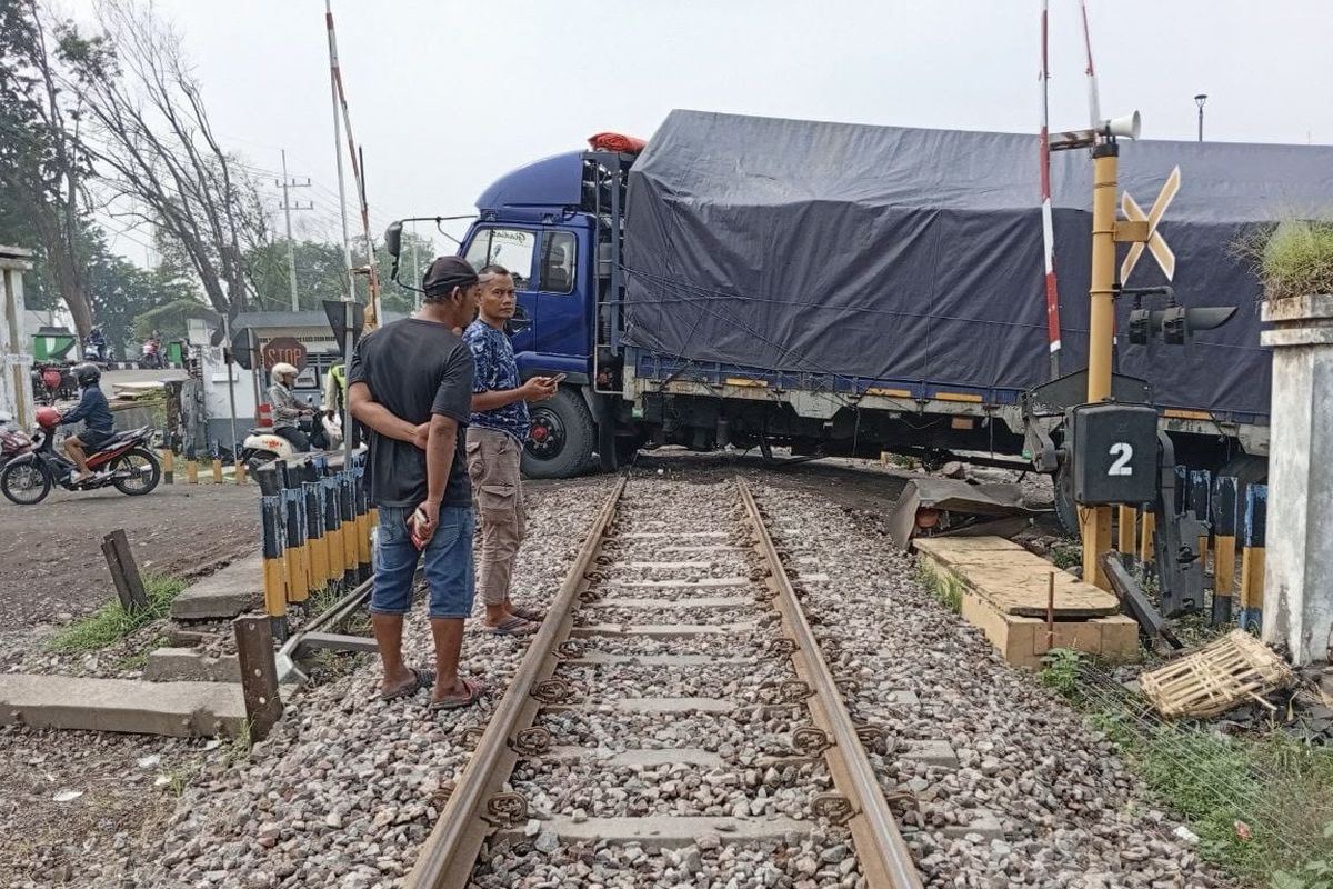 Truk mogok di perlintasan kereta Sidoarjo, Jumat (24/1/2025). Akibatnya, empat perjalanan kereta api sempat terganggu.