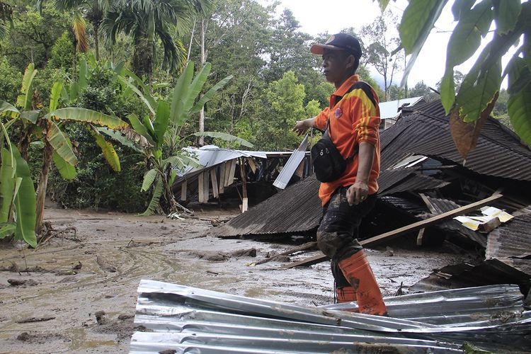 Petugas Badan Penanggulangan Bencana Daerah (BPBD) Agam berada di dekat rumah yang rusak diterjang banjir bandang, di Jorong Galapuang, Nagari Tanjungsani, Kab.Agam, Sumatera Barat, Kamis (21/11/2019). Data BPBD Kabupaten Agam banjir bandang yang terjadi pada Rabu (20/11/2019) sore itu menghanyutkan dua rumah semi permanen dan merendam belasan rumah dan masjid di daerah itu. ANTARA FOTO/Kuraiman/Ief/nz