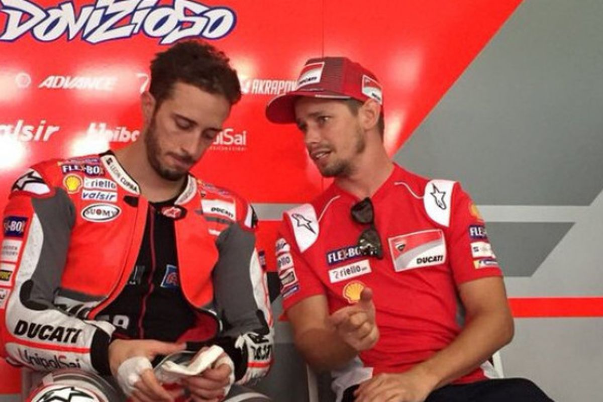 Pebalap Ducati, Andrea Dovizioso, sedang berdiskusi dengan Casey Stoner saat menjalani tes pramusim di Sirkuit Sepang, Selangor, Malaysia (28/1/2018).
