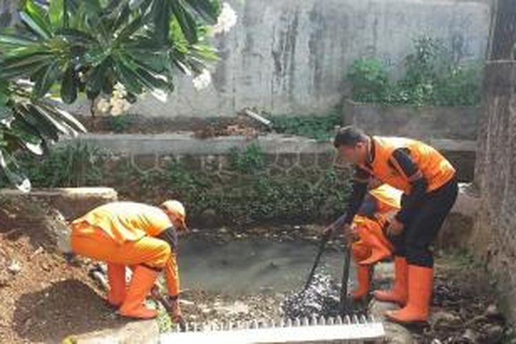 Sejumlah petugas pemeliharaan prasarana dan sarana umum (PPSU) membersihkan saluran air disekitar wilayah Pesanggrahan, Jakarta Selatan pada Rabu (30/12/2015)