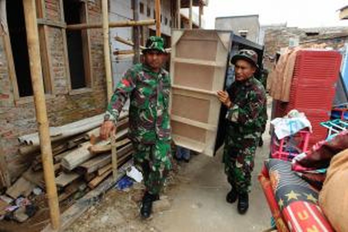 Anggota TNI melakukan pengosongan paksa Kompleks Batalyon Siliwangi, Cililitan, Jakarta Timur, Kamis (8/1/2015). Pengosongan dilakukan terkait rencana pembangunan rumah susun bagi prajurit aktif di lokasi itu. Pengosongan paksa ini sempat mendapat perlawanan warga.