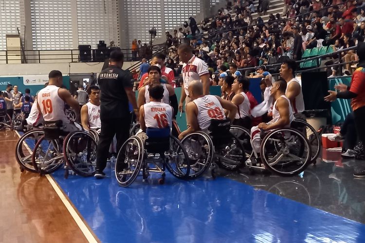 Para pemain timnas basket kursi roda 5x5 putra Indonesia untuk ASEAN Para Games 2022, sedang mendengarkan instruksi pelatih Fajar Brillianto pada sela-sela pertaningan melawan Filipina di GOR Sritex Arena, Rabu (3/8/2022) sore WIB.