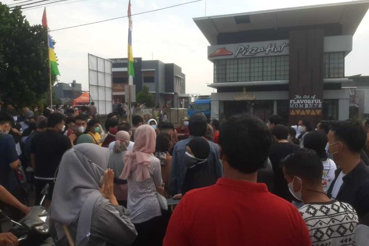 Ratusan warga memadati area parkir Pizza Hut Labuhan Ratu, Bandar Lampung, Sabtu (24/7/2021). Kedatangan warga dipicu beredarnya foto jadwal vaksin keliling kepolisian yang digelar di lokasi itu.