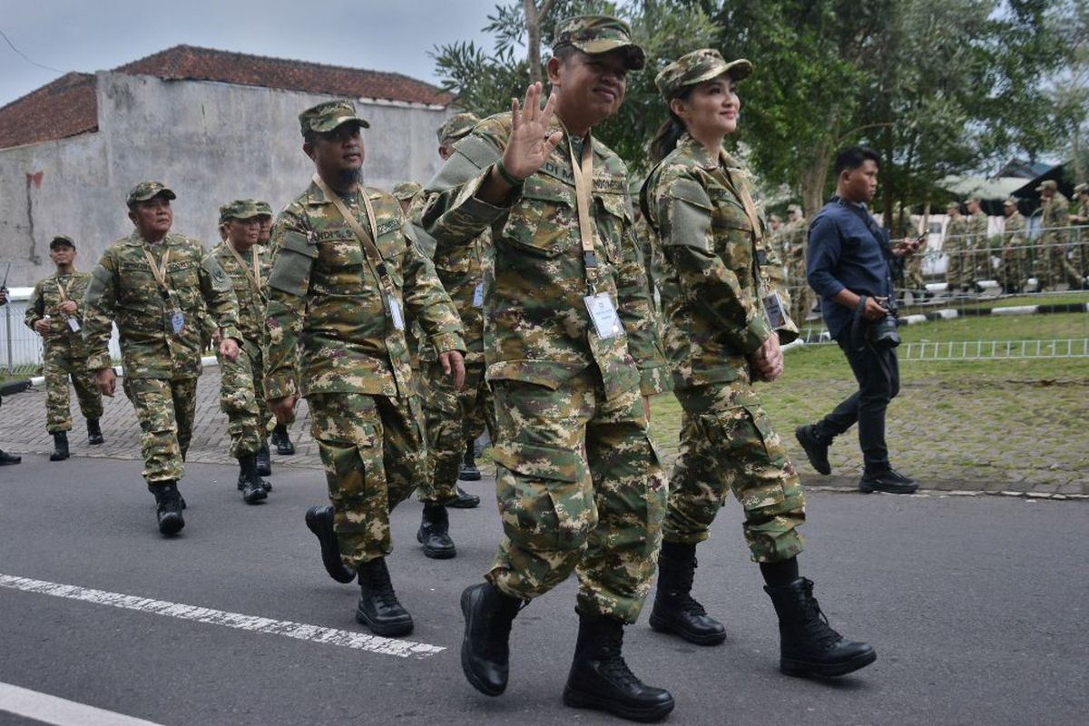 Gubernur Jawa Barat Dedi Mulyadi (kiri) bersama Gubernur Maluku Utara Sherly Laos (kanan) mengenakan seragam komponen cadangan (komcad) menyapa warga setibanya di Kompleks Akademi Militer Magelang, Jawa Tengah, Jumat (21/2/2025). Sebanyak 450 kepala daerah dari seluruh Indonesia akan mengikuti retret pada 21- 28 Februari 2025. ANTARA FOTO/Anis Efizudin/rwa.
