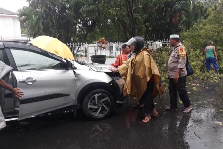 Sebuah mobil yang tertimpa pohon tumbang tepat di samping rujab gubernur Sulawesi Selatan, Jumat (3/1/2020).