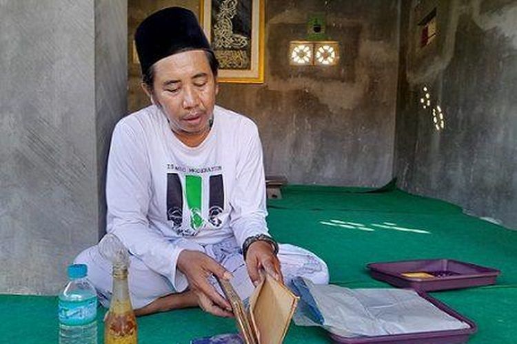 Akhmad Fakih atau Kanjeng Lora menunjukkan kitab, jimat, dan minyak yang digunakan untuk 'membantu klien-kliennya'.