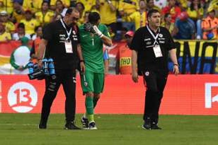 Kiper tim nasional Cile, Claudio Bravo (tengah), berjalan meninggalkan lapangan setelah mengalami cedera pada laga Kualifikasi Piala Dunia 2018 Zona Amerika Selatan melawan Kolombia, di Estadio Metropolitano Roberto Melendez, Kamis (10/11/2016) waktu setempat.