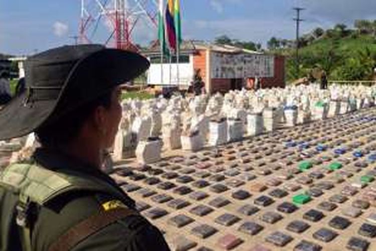 Seorang petugas kepolisan Kolombia menjaga berton-ton paket kokain siap edar yang disita dari sebuah kebun pisang di wilayah utara negeri itu,