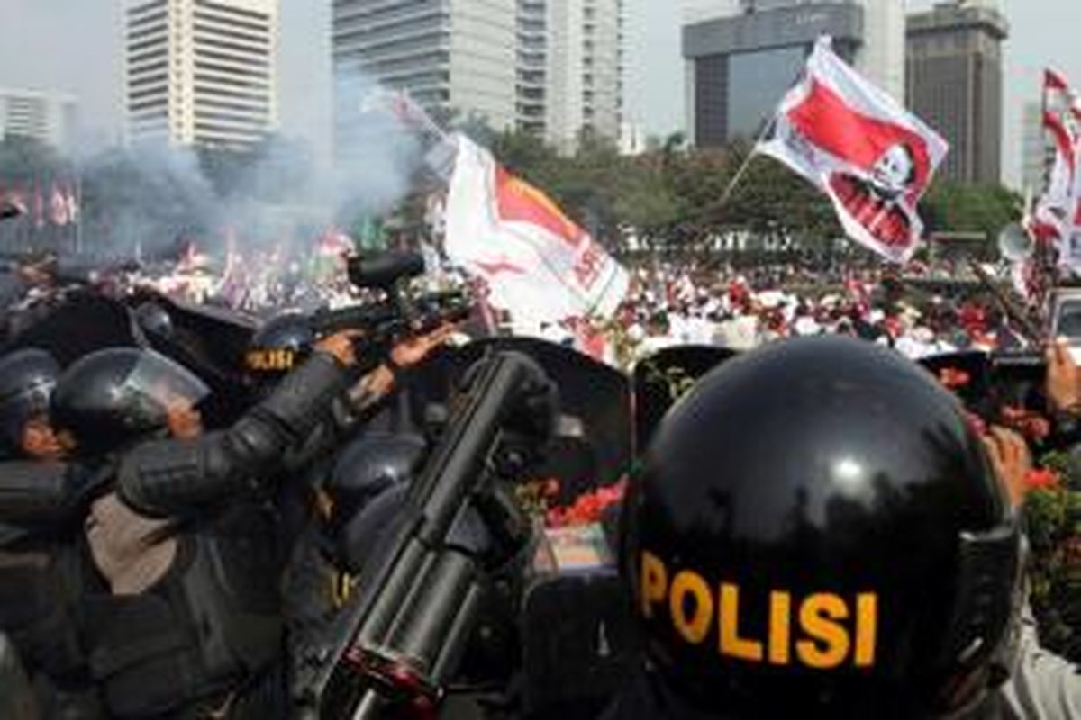 Polisi menembakkan gas air mata dan meriam air ke arah massa pendukung Prabowo-Hatta yang mendesak mendekati Gedung Mahkamah Konstitusi (MK), Jakarta Pusat, Kamis (21/8/2014). Massa memaksa mendekati Gedung MK melalui Jalan Medan Merdeka Barat yang disterilkan polisi karena adanya sidang putusan gugatan Pilpres 2014. 