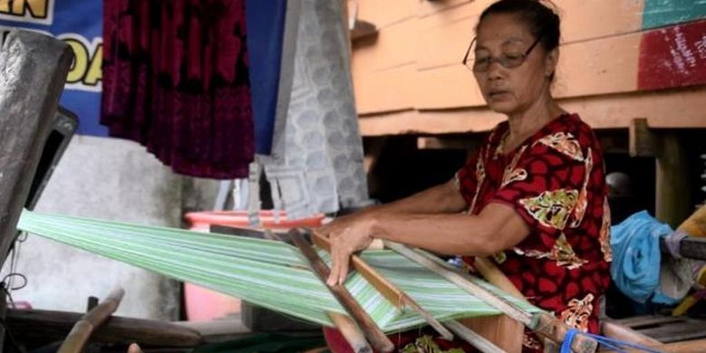 Seorang warga Kampung Tenun Sulaa, Kelurahaan Sulaa, Kecamatan Betoambari, Kota Baubau, Sulawesi Tenggara, Kamis (14/3/2019) sedang menenun di depan rumahnya. 