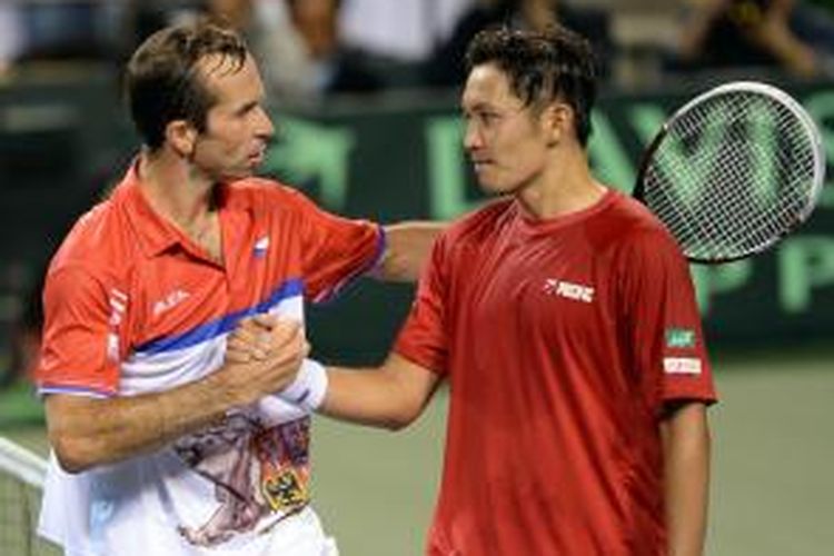 Petenis Ceko Radek Stepanek (kiri) bersalaman dengan Tatsuma Ito dari Jepang setelah pertandingan pada perempat final Davis Cup di Ariake Coliseum, Tokyo, Jumat (4/4/2014). Stepanek menang 6-7(5), 7-6(5), 6-1, 7-5.