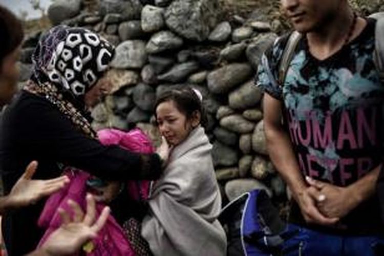 Seorang anak perempuan menangis saat berhasil tiba bersama pengungsi lainnya di Pulau Lesbos, Yunani, setelah menyeberngi laut Aegean dari Turki, 29 September 2015.