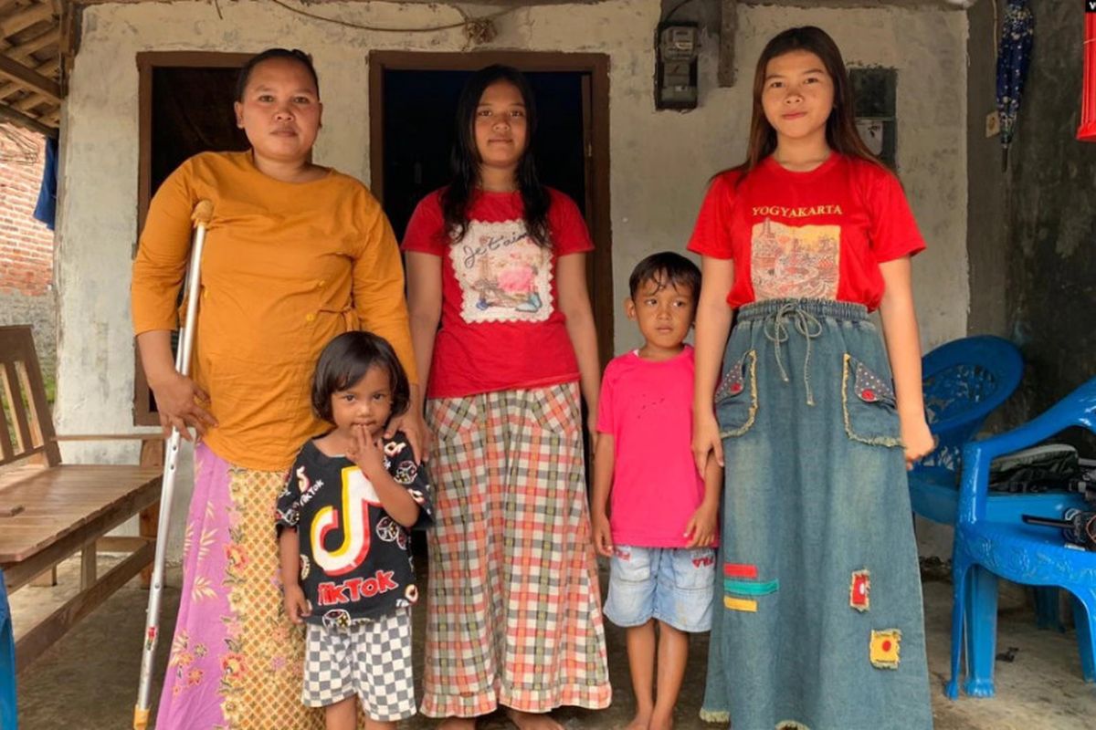 Rasminah (kiri) bersama empat dari lima anaknya di depan rumah mereka di Indramayu, Jawa Barat, Minggu, 7 Maret 2021.