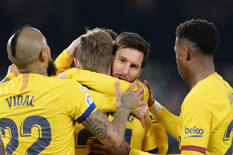 Barcelonas Dutch midfielder Frenkie De Jong (2L) is congratulated by Barcelonas Argentine forward Lionel Messi during the Spanish league football match between Real Betis and FC Barcelona at the Benito Villamarin stadium in Seville on February 9, 2020. (Photo by CRISTINA QUICLER / AFP)