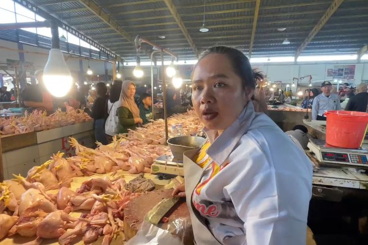 Winda Azmiyatin (47) salah seorang pedagang daging ayam di Pasar Sehat Soreang, saat melayani pembeli, Winda merupakan janda dengan dua orang anak, dia bertahan hidup dari warisan jongko daging ayam peninggalan mendiang suaminya, Rabu (3/12/2025)