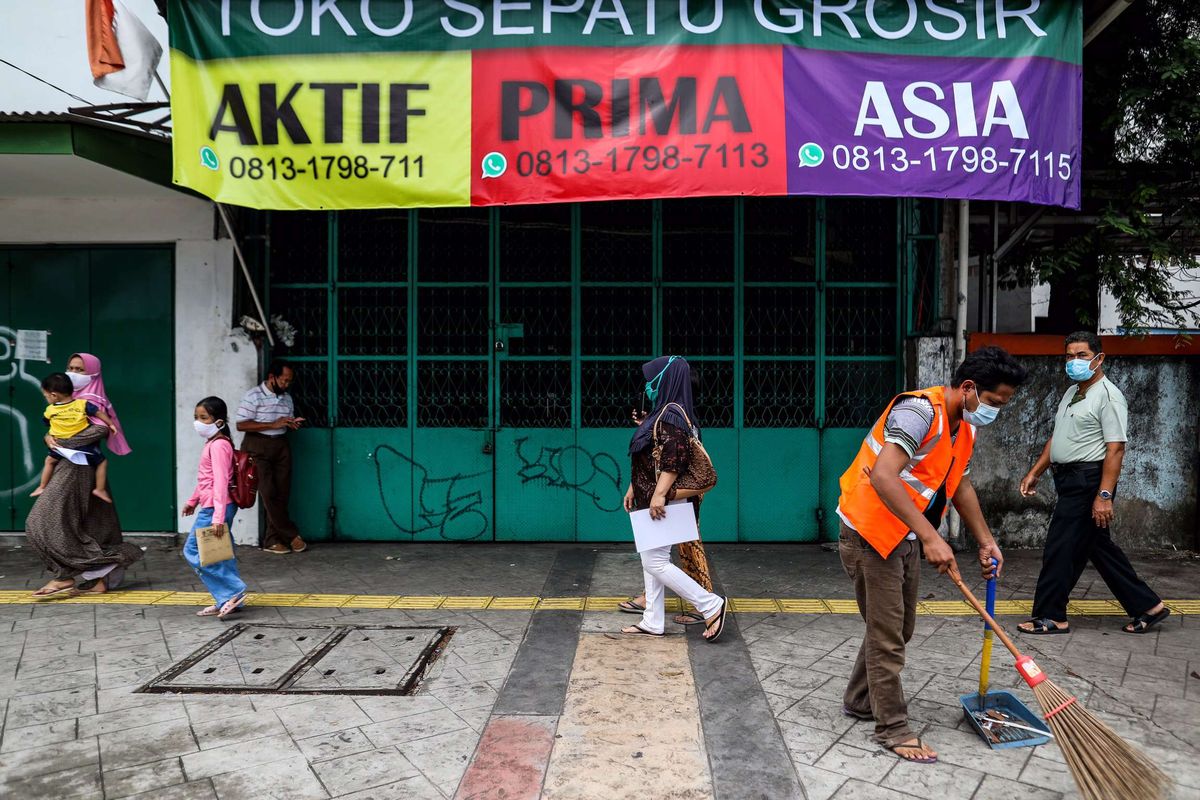 Seorang warga menyapu di trotoar jalan karena tidak menggunakan masker saat patroli penegakan aturan pembatasan sosial berskala besar (PSBB) di Jl. Matraman Raya, Kecamatan Jatinegara, Jakarta Timur, Selasa (19/5/2020). Dalam kegiatan patroli PSBB tersebut, target penegakan untuk masyarakat yang tidak mengunakan masker dijalanan.