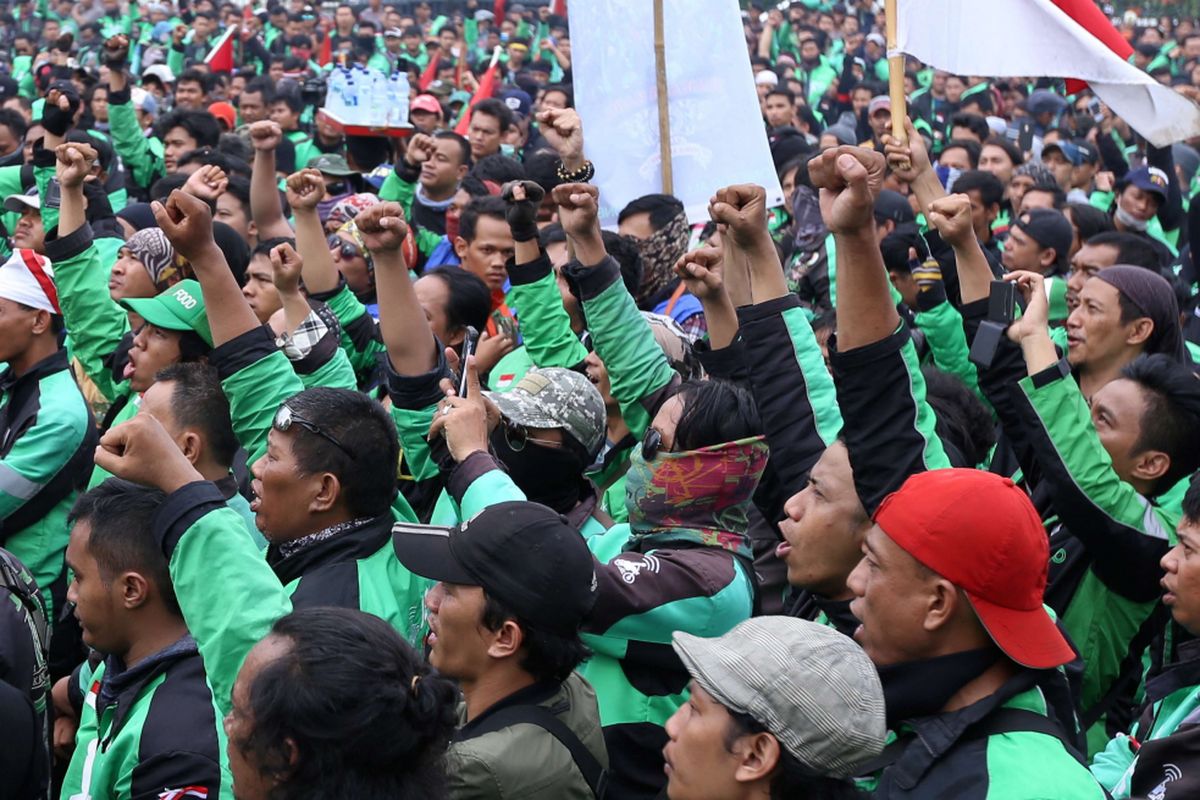 Sejumlah massa ojek online berunjuk rasa saat demo di depan Gedung DPR/MPR RI untuk berunjuk rasa menyampaikan aspirasinya, Senin (23/4/2018). Dalam demo ini para  pengemudi ojek online menuntut kenaikan tarif, Pengakuan legal, dan perlindungan hukum dan keadilan bagi ojek online.