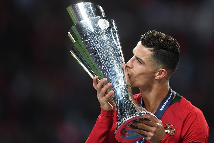 Pemain Portugal Cristiano Ronaldo mencium trofi saat merayakan kemenangan timnya atas Belanda usai laga final UEFA Nations League di Stadion do Dragao, Porto, Minggu (9/6/2019) atau Senin dini hari WIB. Portugal berhasil menjadi juara UEFA Nations League seusai menang 1-0 atas Belanda.