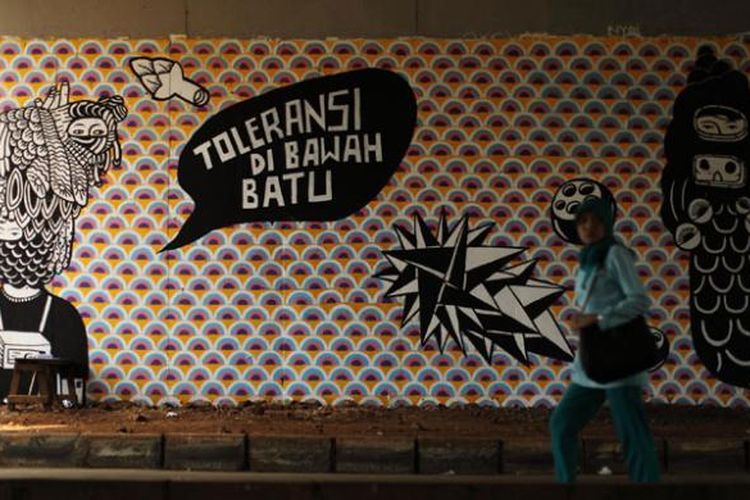 Mural berjudul Toleransi di Bawah Batu karya seniman Eko Nugroho di dinding kolong Tol Bintaro, Jakarta, Selasa, (12/11/2013). Gambar mural ini merupakan bagian dari Jakarta Biennale ke-15 yang mengambil tema Siasat.