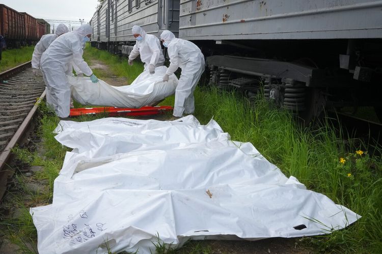 Prajurit Ukraina mengumpulkan mayat tentara Rusia untuk dimuat ke gerbong kereta api kulkas di Kyiv, Ukraina, Jumat, 13 Mei 2022. 