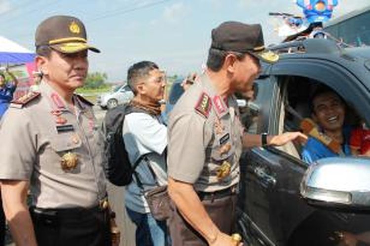 Kepala Polri Jenderal Polisi Sutarman berbincang dengan pemudik membawa replika motor polisi lalu lintas di atas mobilnya di pintu keluar Tol Pejagan, Brebes, Jawa Tengah, Minggu (27/7/2014).