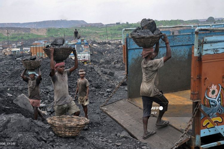 Foto yang diambil pada 7 Desember 2017 ini menunjukkan para buruh India memuat batu bara ke truk di sebuah tambang terbuka di Dhanbad, Negara Bagian Jharkhand, India timur. Ratusan juta orang di India terpaksa hidup dengan dampak dari energi paling kotor, batu bara, di mana pemerintah menyalahkan kurangnya dana untuk meningkatkan produksi listrik dari sumber yang lebih hijau.