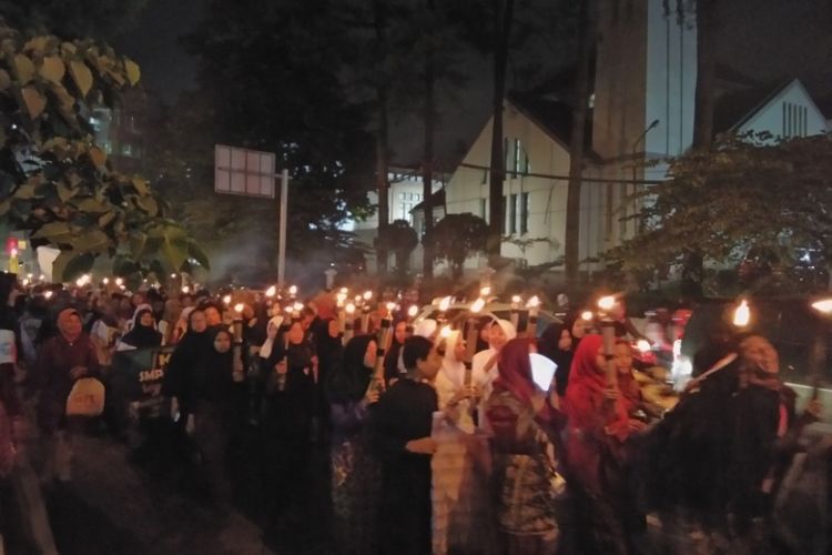 Ribuan warga Bandung saat membawa obor dalam peringatan sejarah Bandung Lautan Api ke 72, Jumat (23/3/2018) malam. 