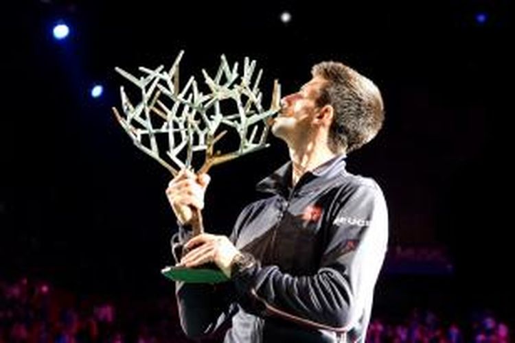 Petenis Serbia, Novak Djokovic, mencium trofi juara Paris Masters yang didapat setelah mengalahkan petenis Kanada, Milos Raonic, pada laga final di Bercy Palais-Omnisport, Paris, Minggu (2/11/2014). Djokovic menang 6-2, 6-3.