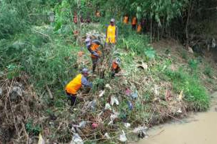 Warga membersihkan potongan bambu dan plastik pada acara bersih-bersih sungai di Desa Glonggong, Kecamatan Balerejo, Sabtu (12/11/2016).