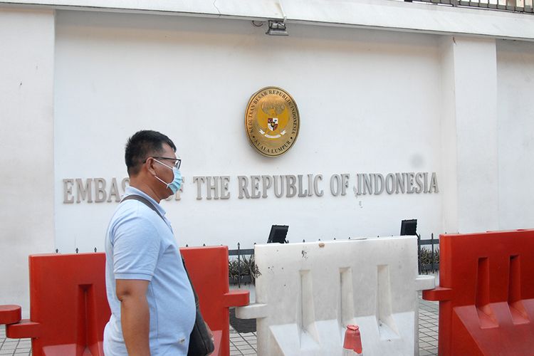 Seorang WNI berjalan di depan kantor Kedutaan Besar Republik Indonesia (KBRI) di Kuala Lumpur, Malaysia, Selasa (17/3/2020). Sejumlah layanan di KBRI KL terpaksa dihentikan untuk sementara waktu setelah Perdana Menteri Malaysia Muhyiddin Yassin mengumumkan bahwa pemerintah Malaysia memutuskan untuk melaksanakan lockdown (Perintah Kawalan Pergerakkan) mulai 18 Maret hingga 31 Maret 2020 di seluruh negara bagian dalam rangka mengatasi penyebaran wabah COVID-19.