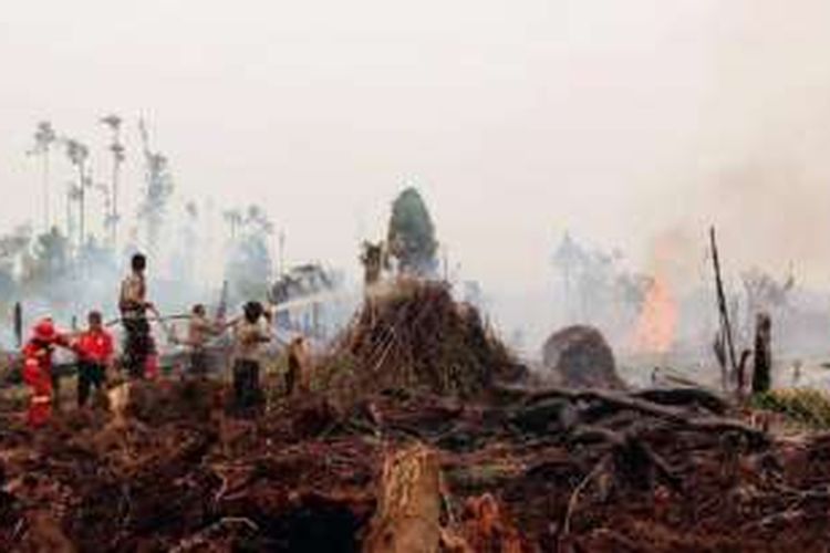 Kebakaran hutan dan lahan terjadi di area persiapan perkebunan kelapa sawit PT Sontang Sawit Permai, Kecamatan Bonai Darussalam, Kabupaten Rokan Hulu, Riau. Aparat Kepolisian Sektor Bonai Darussalam bersama personel pemadam dari PT Bina Daya Bentala, Sinar Mas Forestry Group, berupaya memadamkan api, Minggu (28/8/2016).