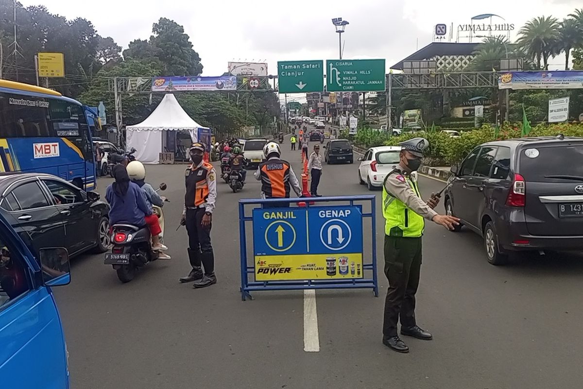 Petugas Satlantas Polres Bogor menjaring kendaraan yang melanggar aturan ganjil genap di Puncak Bogor, Jawa Barat, Sabtu (24/12/2022).