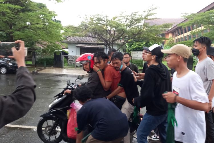 Sejumlah mahasiswa menolong rekannya untuk dilarikan ke rumah sakit saat demo berlangsung di Kabupaten Lebak, Senin (11/4/2022).