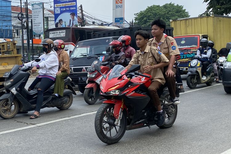 Pelajar SMP di bawah umur mengendarai motor sembari merokok dan tidak menggunakan helm 