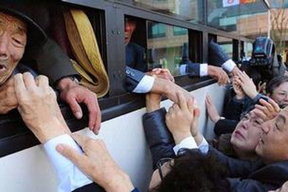 Warga Korut yang berada dalam bus memberikan salam perpisahan kepada saudara mereka dari Korsel sebelum kembali ke rumah setelah sebuah reuni yang mempertemukan mereka pada 1 November 2010 di Gunung Kumgang, Korut. Mereka telah terpisah sekitar 60 tahun akibat Perang Korea.