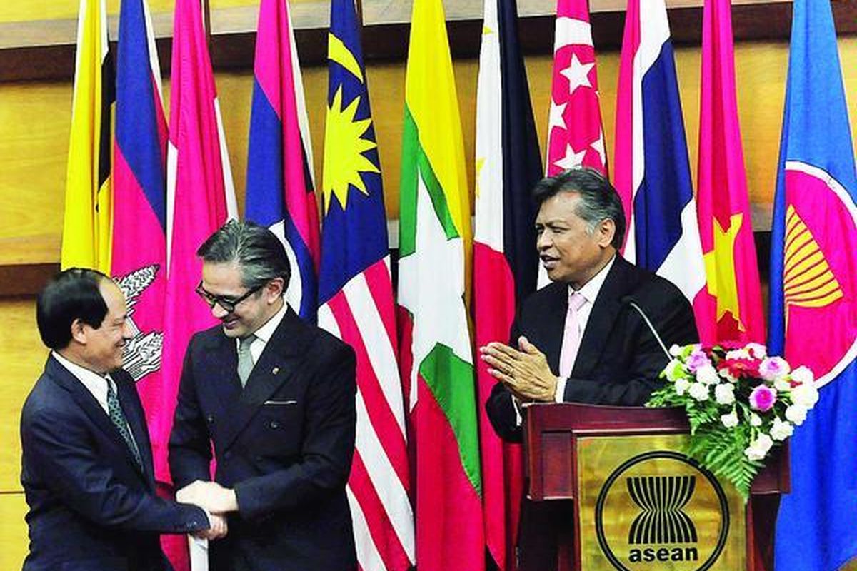 Sekretaris Jenderal ASEAN yang baru, Le Luong Minh (kiri), berjabat tangan dengan Menteri Luar Negeri RI Marty Natalegawa, disaksikan mantan Sekjen ASEAN Surin Pitsuwan pada serah terima jabatan Sekjen ASEAN, di Kantor Sekretariat ASEAN, Jakarta, Rabu (9/1). Le Luong Minh, yang sebelumnya Wakil Menlu Vietnam, akan  menjabat Sekjen ASEAN periode 2013-2017.