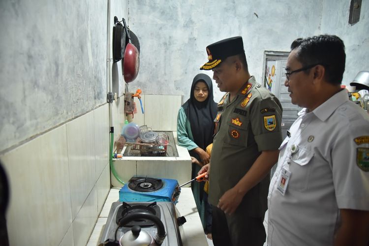 Bupati Kebumen Arif Sugiyanto melihat pemanfaatan gas metana untuk kompor rumah warga di sekitar Tempat Pengelolaan Akhir (TPA) Kaligending, Kecamatan Karangsambung, Kebumen, Jawa Tengah,  Rabu (22/2/2023).
