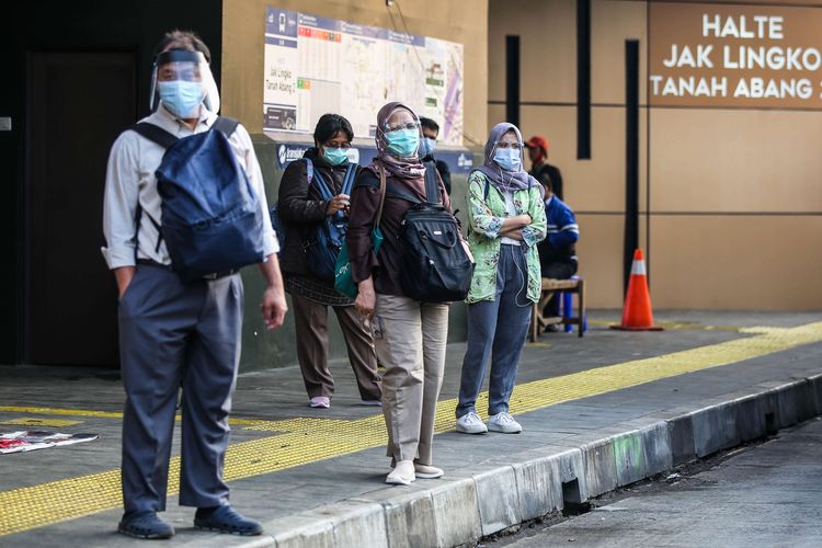 Pekerja yang menggunakan masker saat menunggu bus disekitar Stasiun Tanah Abang di Jakarta Pusat, Senin (14/9/2020). PSBB kembali diterapkan tanggal 14 September 2020, berbagai aktivitas kembali dibatasi yakni aktivitas perkantoran, usaha, transportasi, hingga fasilitas umum.