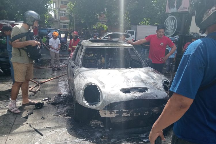 Mobil Mini Cooper bernomor polisi DK 1811 DNI warna merah marun hangus terbakar saat parkir di Jalan Raya Puputan, Renon, Kota Denpasar, Bali, pada Senin (3/6/2024). /Dok. Humas Polresta Denpasar