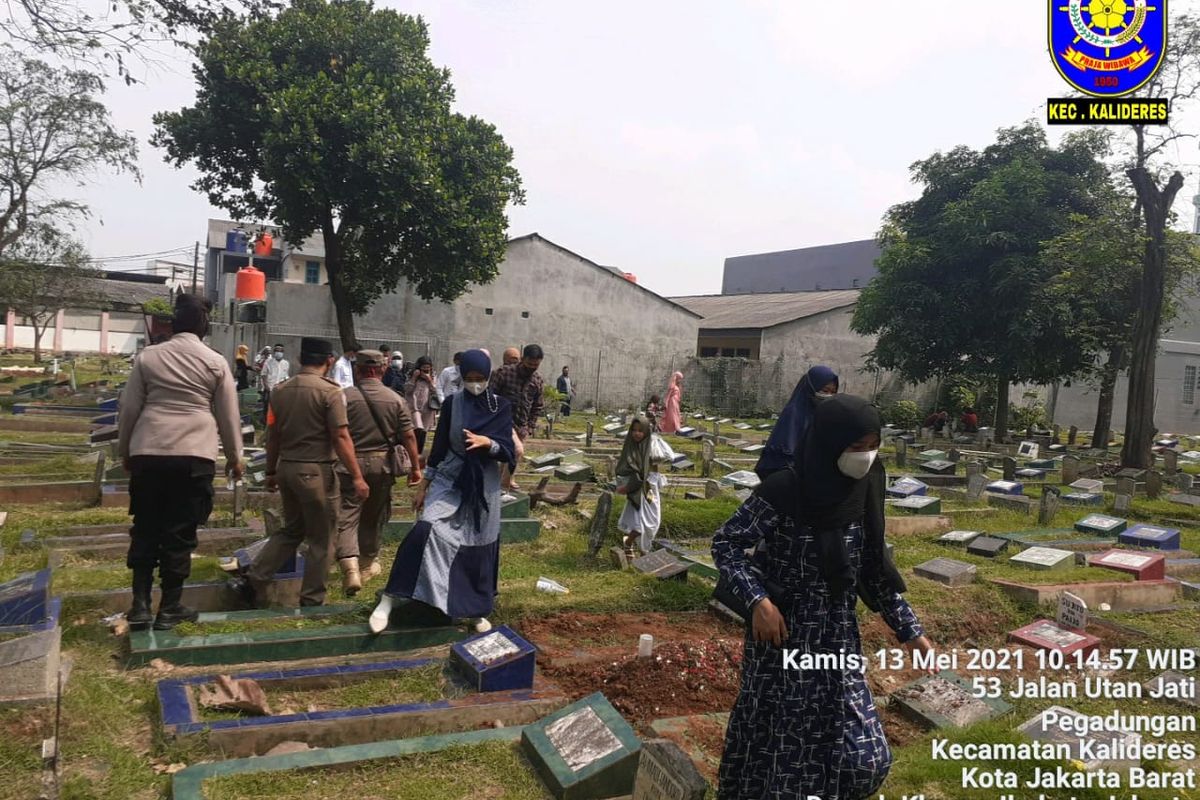 Satpol PP menghalau peziarah di TPU Utan Jati, Kalideres , Jakarta Barat, Kamis (13/5/2021).