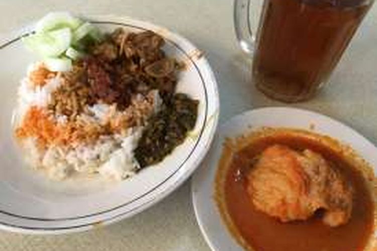 Sepiring nasi putih disajikan bersama sayur nangka, potongan timun, sambal hijau, sedikit kuah kari dan bumbu rendang.