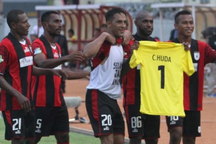 Penyerang Persipura Jayapura, Boaz Solossa, membentangkan baju berwarna kuning bertuliskan Choirul Huda usai mencetak gol ke gawang Persija Jakarta di Stadion Mandala, Jayapura, Rabu (18/10/2017).