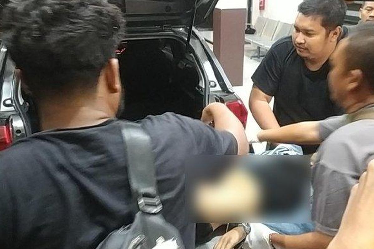 Jenazah AYE dievakuasi dari dalam bagasi mobil petugas kepolisian ke kamar mayat RS Bhayangkara Surabaya, pada Jumat (7/3/2025). AYE, pelaku pencurian motor yang kerap mempersenjatai diri dengan celurit saat menjalankan aksinya.  