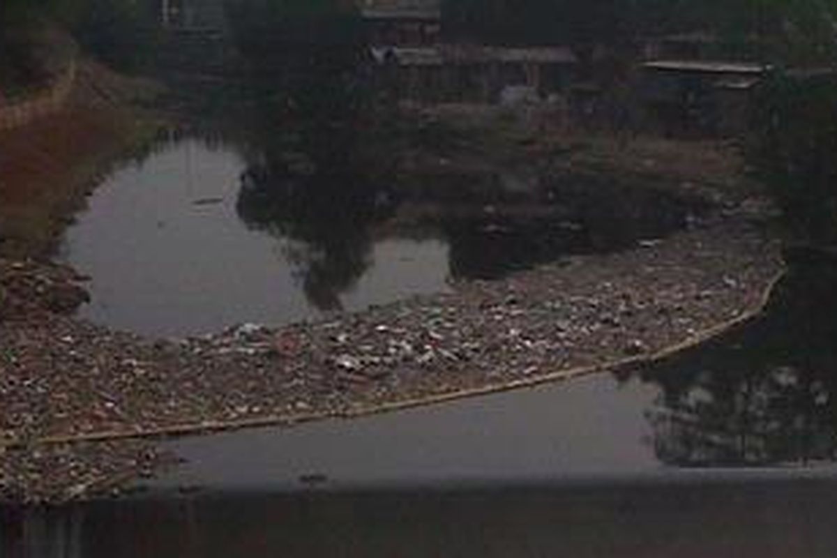 Sebuah bambu panjang digunakan sebagai sekat penahan sampah di kawasan Cipinang Besar Selatan, Jakarta Timur, di mana kanal banjir timur (KBT) berbatasan langsung dengan Kali Cipinang, Kamis (2/8/2012). Sekat ini difungsikan sebagai penahan sampah agar tak masuk ke KBT.