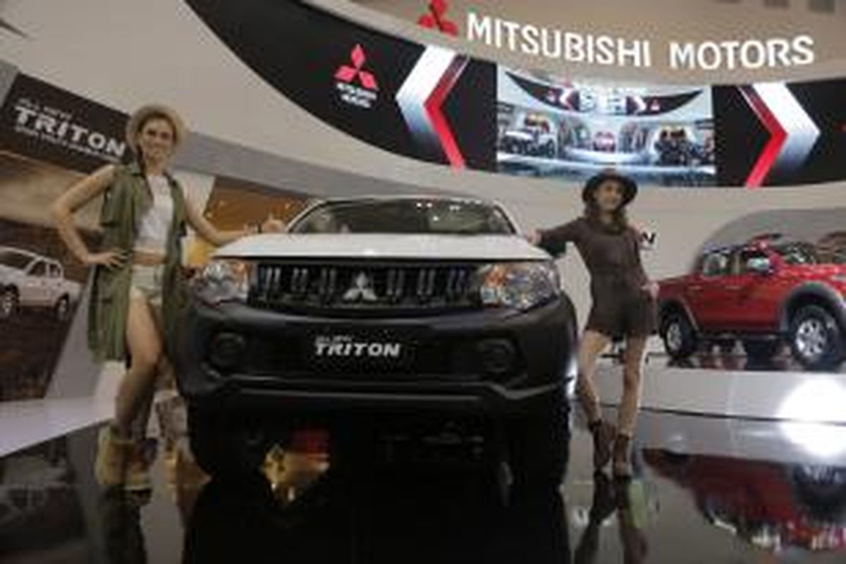 Model stan Mitsubishi berpose dalam pameran Gaikindo Indonesia International Auto Show 2015 di Indonesia Convention Exhibition (ICE), Tangerang Selatan, Banten, Kamis (20/8/2015). Pameran otomotif yang diikuti oleh 350 peserta ini akan berlangsung hingga 30 Agustus.