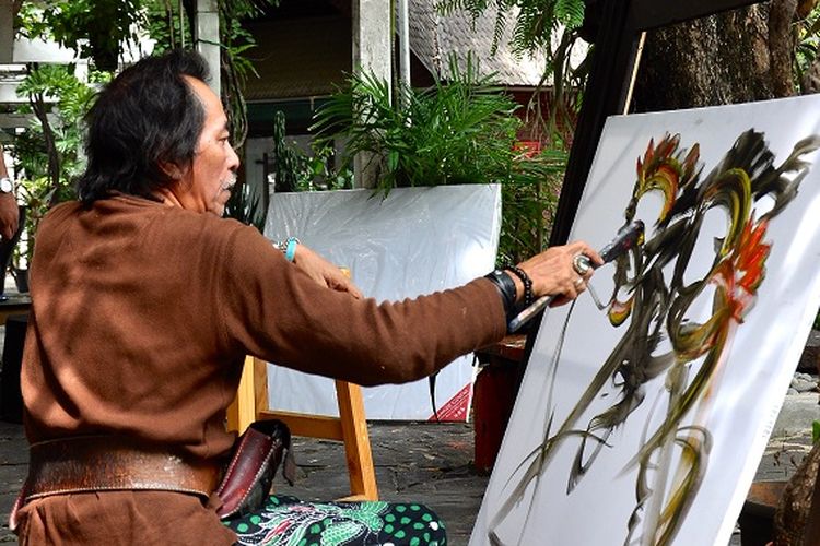 Seorang seniman melukis di Pasar Seni, Taman Impian Jaya Ancol, Jakarta DOK. Shutterstock/henry gunawan